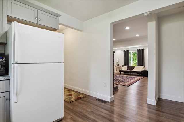 kitchen featuring gray cabinetry, white refrigerator, and dark wood-type flooring