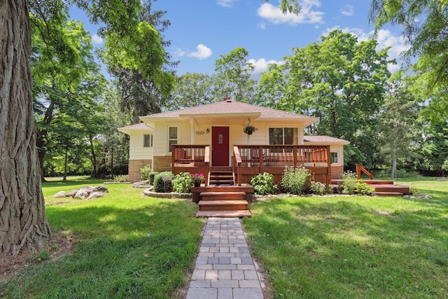 view of front facade with a front yard and a wooden deck