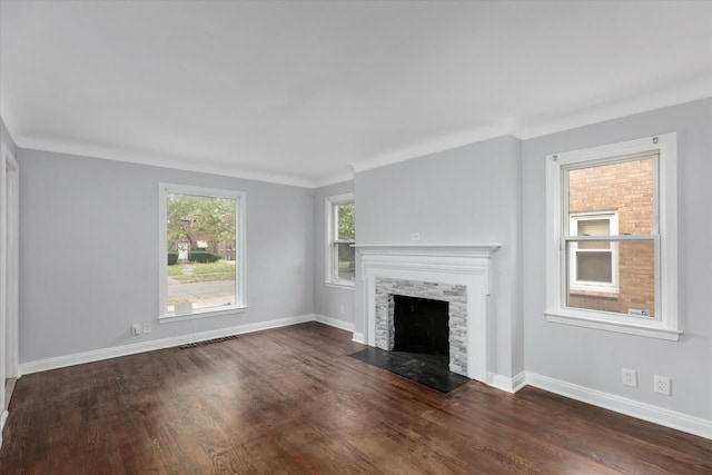 unfurnished living room featuring dark hardwood / wood-style floors, crown molding, and a fireplace