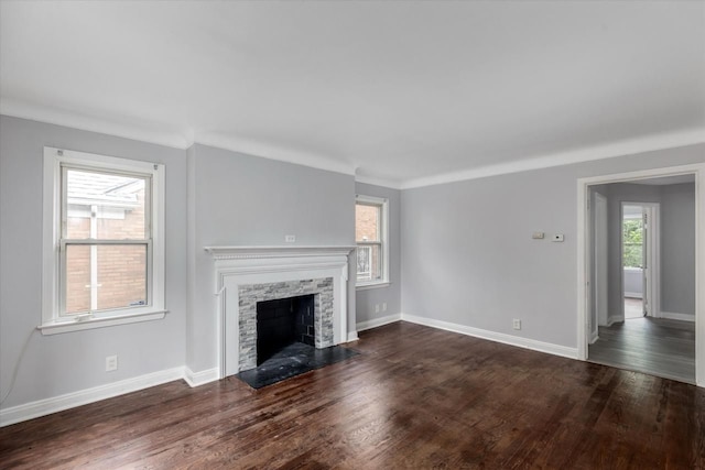 unfurnished living room with a wealth of natural light, a fireplace, and dark wood-type flooring