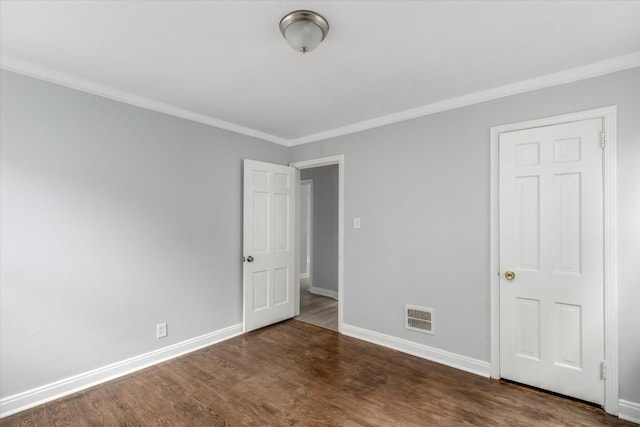 unfurnished bedroom with crown molding and dark wood-type flooring