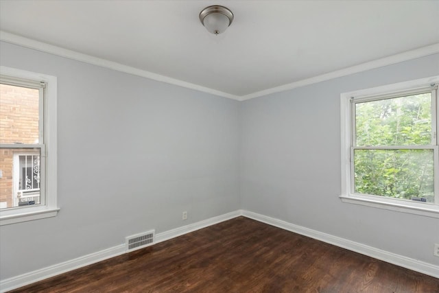 spare room featuring dark hardwood / wood-style flooring and ornamental molding