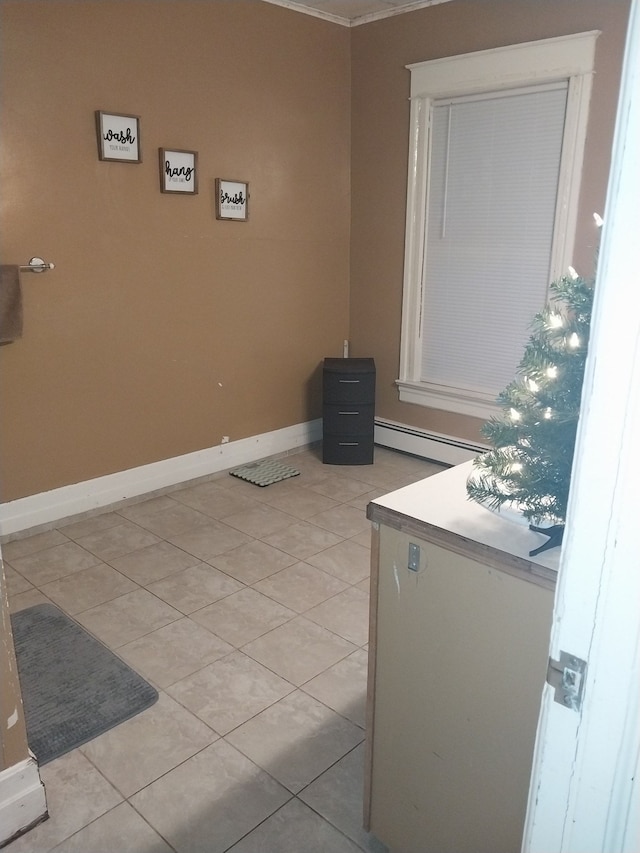 washroom with light tile patterned floors, a baseboard radiator, and crown molding