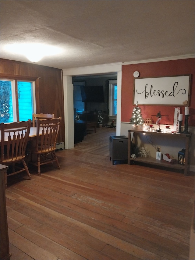 dining area with a textured ceiling, hardwood / wood-style flooring, and ornamental molding