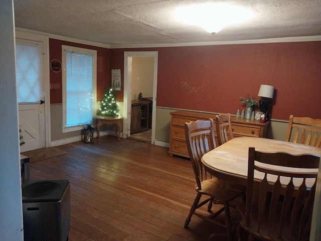 dining room featuring hardwood / wood-style flooring, ornamental molding, and a textured ceiling