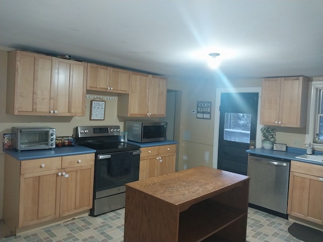 kitchen with sink, stainless steel appliances, and light brown cabinetry