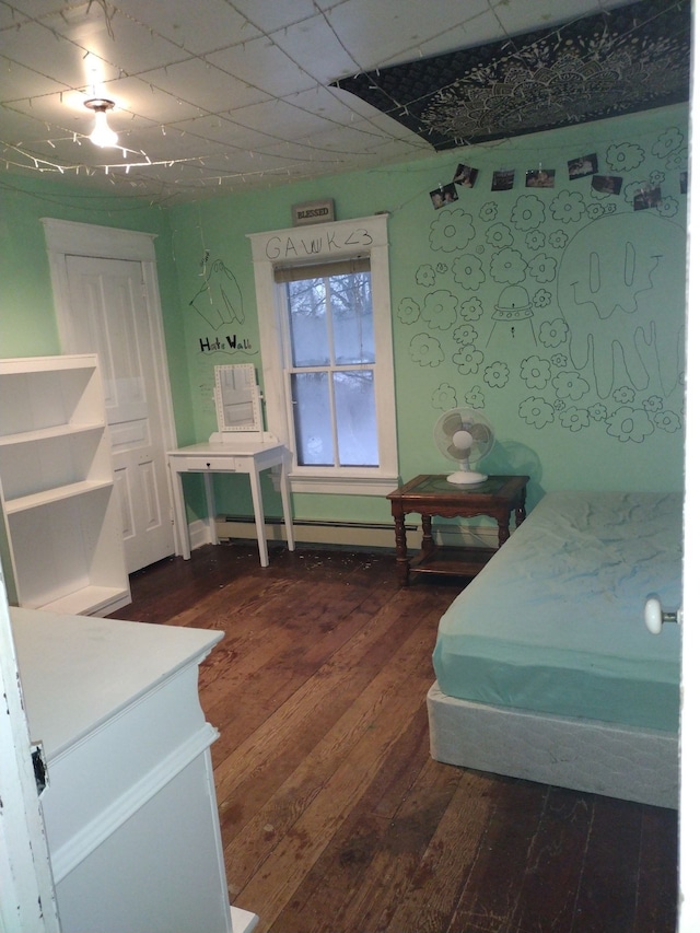 bedroom featuring baseboard heating, a paneled ceiling, and dark wood-type flooring