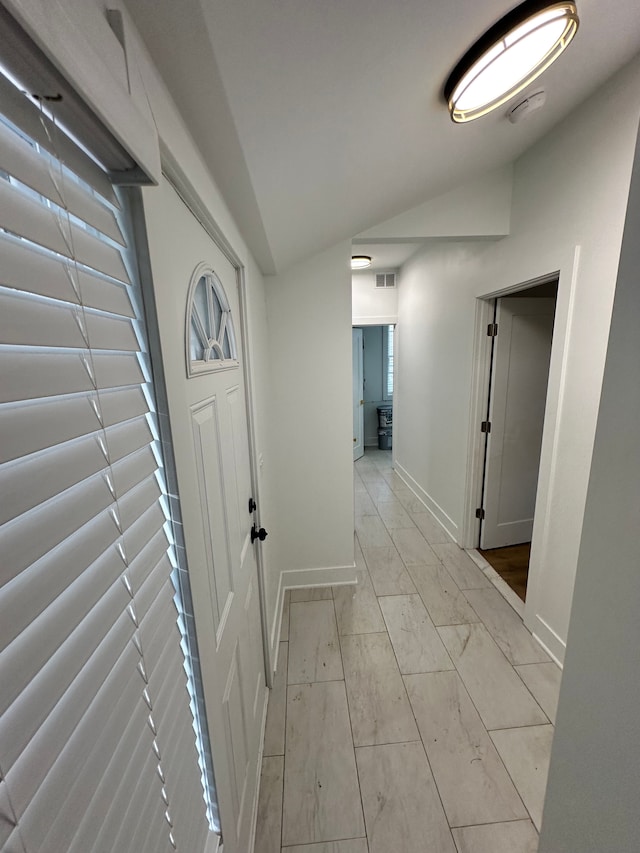 hallway with lofted ceiling