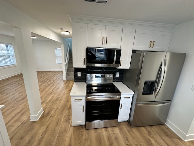 kitchen featuring light hardwood / wood-style flooring, white cabinets, and appliances with stainless steel finishes