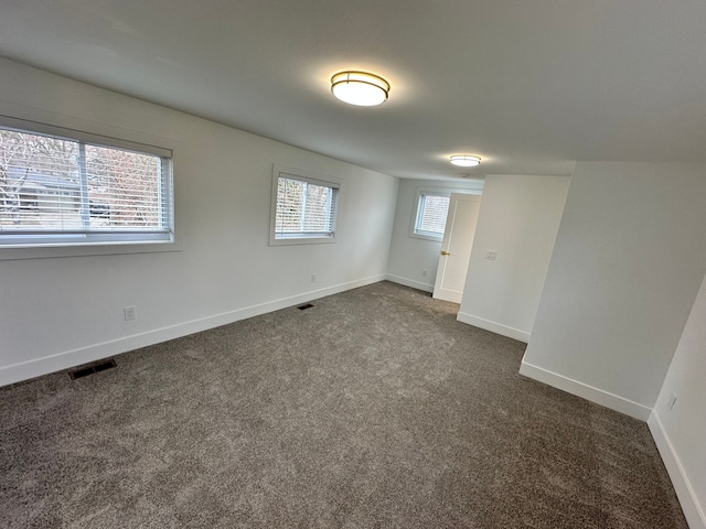 spare room with dark colored carpet