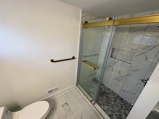 bathroom featuring toilet and a shower with shower door