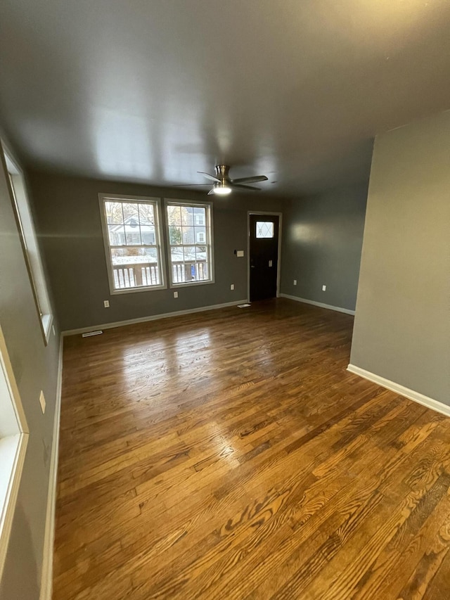 unfurnished living room with wood-type flooring and ceiling fan