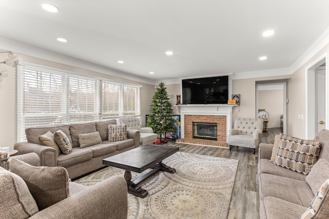 living room featuring hardwood / wood-style floors, a brick fireplace, and crown molding