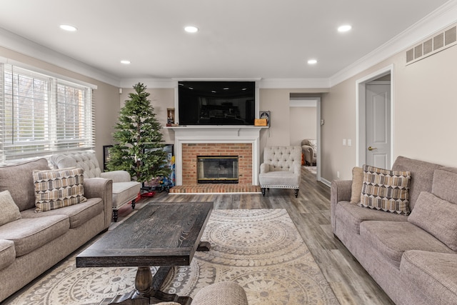 living room with a fireplace, wood-type flooring, and crown molding