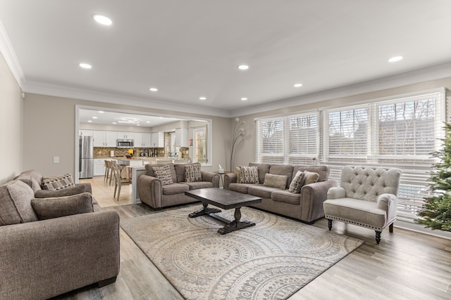 living room featuring light hardwood / wood-style flooring and ornamental molding