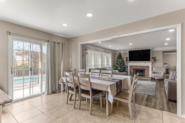 dining space with a fireplace and light tile patterned floors