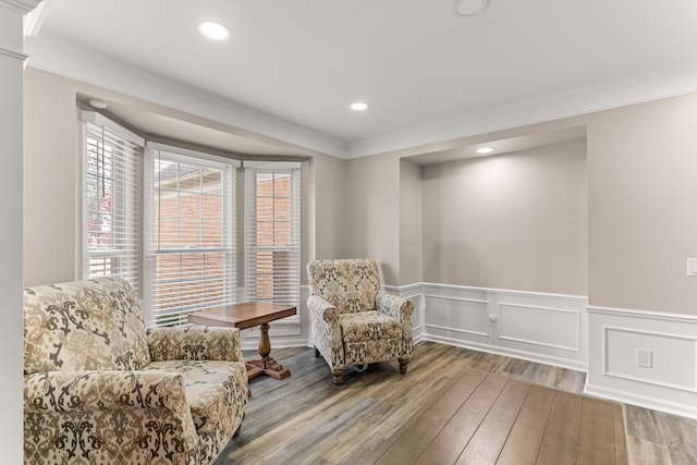 living area featuring wood-type flooring and ornamental molding