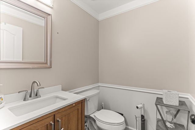 bathroom with vanity, toilet, and ornamental molding