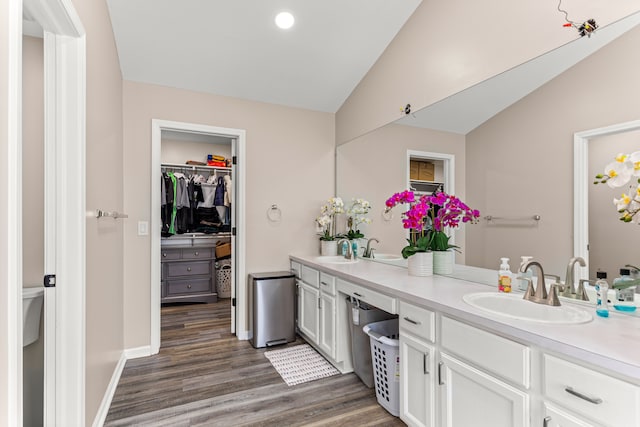 bathroom featuring toilet, vanity, vaulted ceiling, and hardwood / wood-style flooring