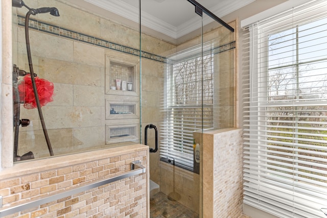 bathroom with crown molding, plenty of natural light, and walk in shower