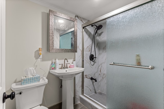 bathroom with sink, toilet, a shower with shower door, and crown molding