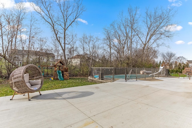 view of patio featuring a playground and a covered pool