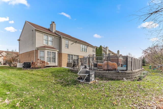 back of property featuring central AC and a yard