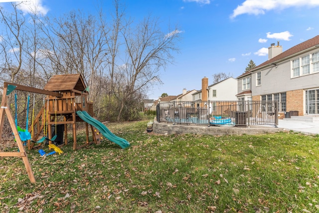 view of playground with a yard and a patio area