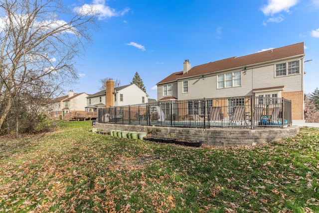 rear view of house with a yard and a deck