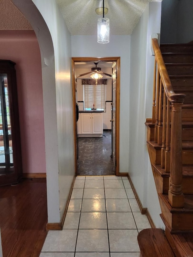 hall with light hardwood / wood-style flooring and a textured ceiling