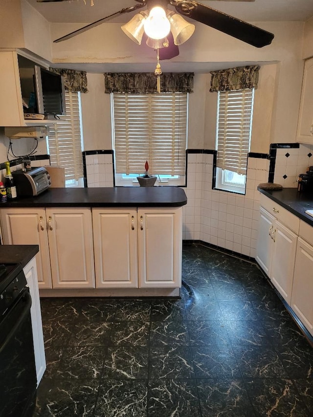 kitchen with white cabinets, black range with electric cooktop, tile walls, and ceiling fan