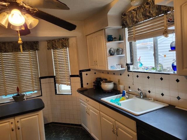 kitchen featuring dishwasher, sink, ceiling fan, and tile walls