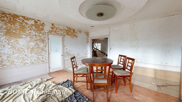 carpeted dining area with crown molding