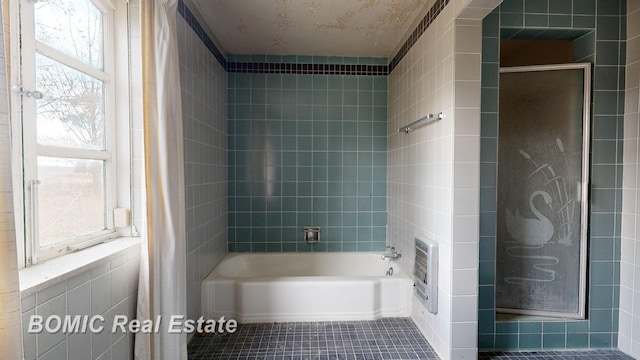 bathroom featuring tile patterned floors, plenty of natural light, tile walls, and independent shower and bath