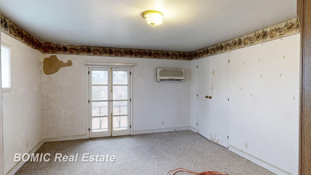 unfurnished room featuring light colored carpet, french doors, and a wall mounted AC