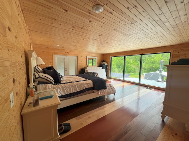 bedroom featuring wood walls, access to exterior, wooden ceiling, and light wood-type flooring