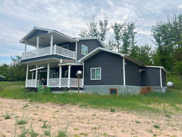 back of property with a porch and a balcony