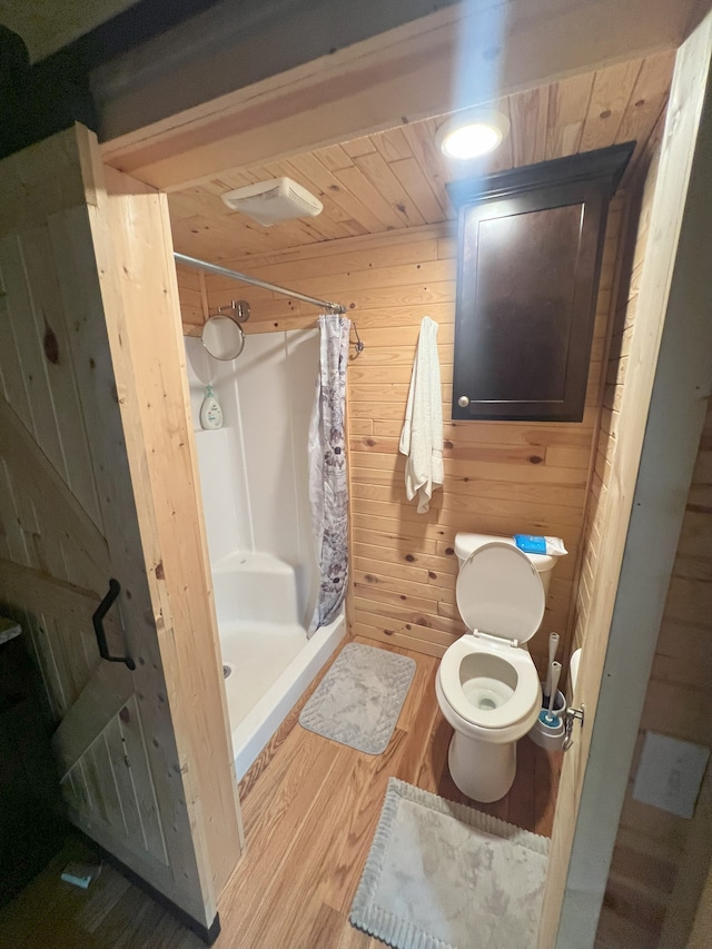 bathroom with curtained shower, wooden ceiling, toilet, wooden walls, and hardwood / wood-style flooring