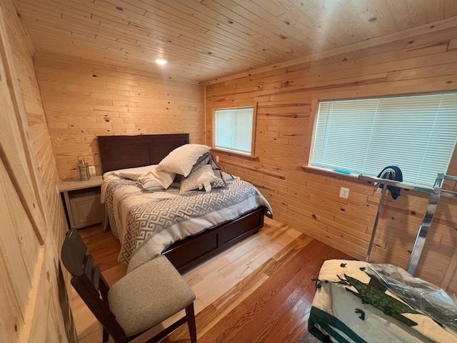 bedroom with wooden ceiling, light hardwood / wood-style flooring, and wooden walls