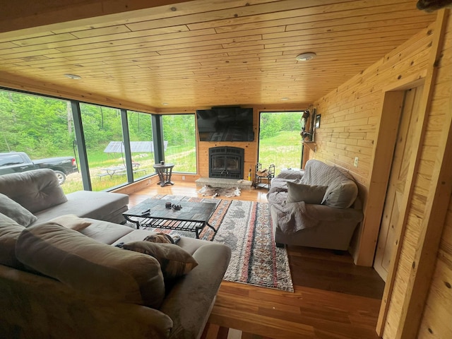 living room featuring hardwood / wood-style floors, lofted ceiling, wood ceiling, and a fireplace