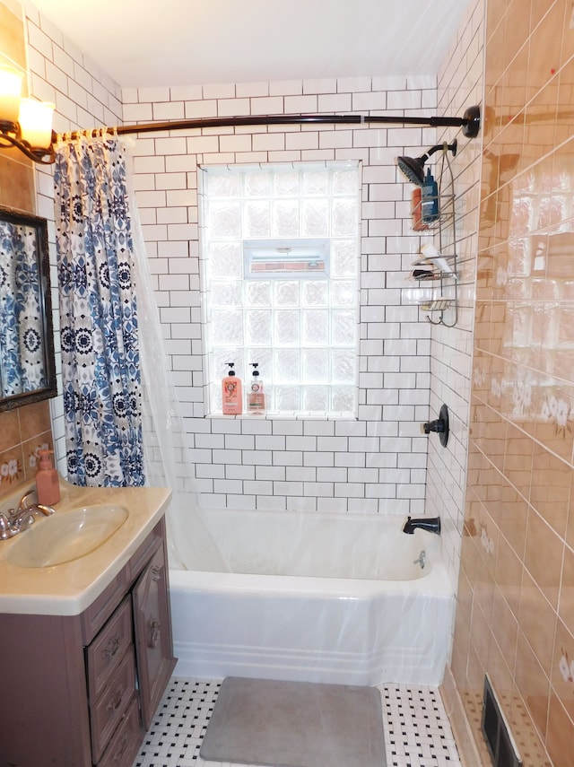 bathroom featuring vanity, tile patterned flooring, shower / bath combo with shower curtain, and tile walls