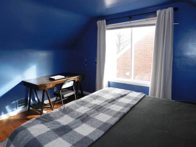 bedroom featuring lofted ceiling and dark hardwood / wood-style flooring