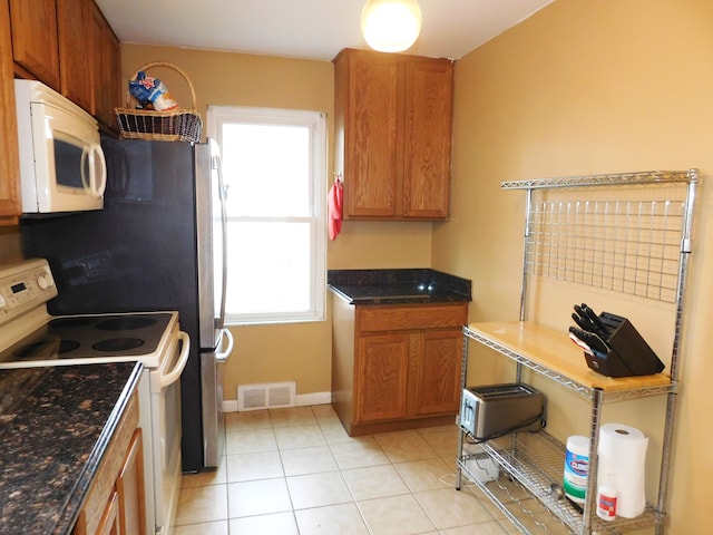 kitchen featuring light tile patterned floors and white appliances