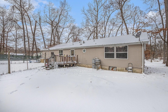 snow covered house featuring a deck