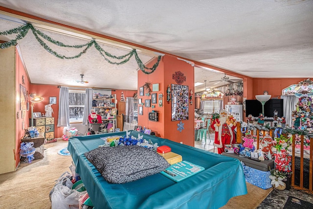 game room with a textured ceiling, carpet floors, vaulted ceiling, and ceiling fan