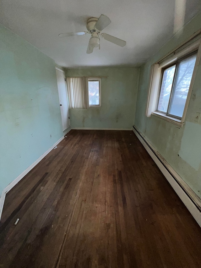 unfurnished room with ceiling fan, dark wood-type flooring, and a baseboard radiator