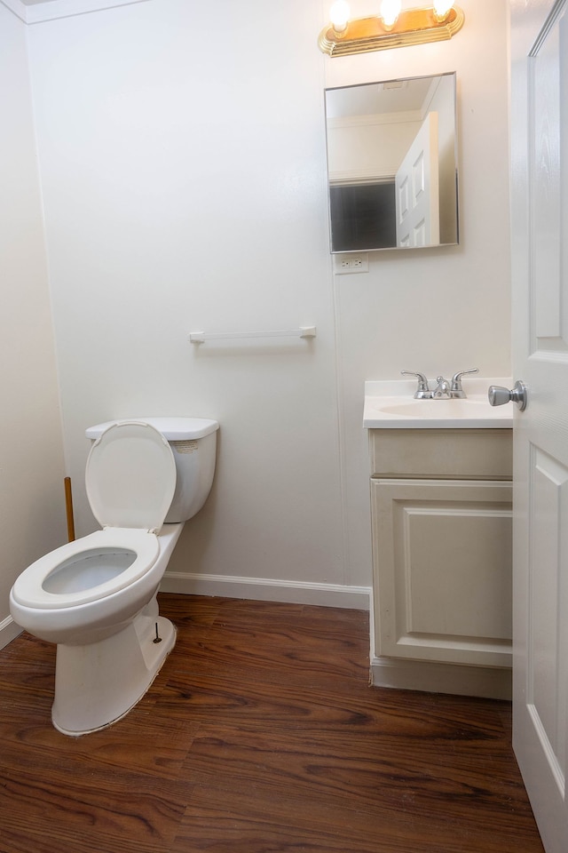 bathroom with hardwood / wood-style floors, vanity, and toilet