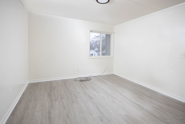 empty room featuring light hardwood / wood-style flooring and ornamental molding