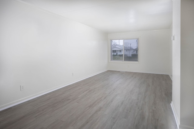 empty room featuring hardwood / wood-style floors and ornamental molding