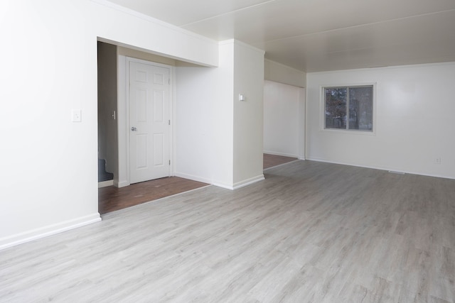 spare room with light wood-type flooring and ornamental molding